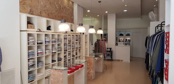 Interior de la tienda José Nolla con pared de piedra y lámparas colgantes